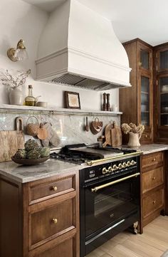 a stove top oven sitting inside of a kitchen next to wooden cabinets and counter tops