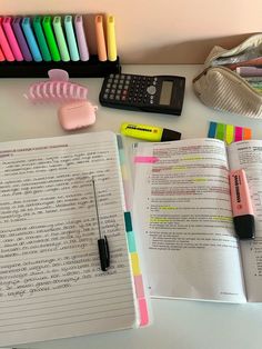 an open book sitting on top of a table next to a calculator and pen