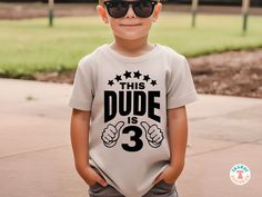 a little boy that is wearing some kind of t - shirt with the words dude is 3 on it