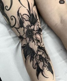 a woman's leg with black and white flowers on it