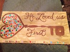 a wooden sign that says he loved us first with an oven and spatula on it