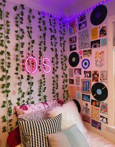 a bedroom with plants and vinyl records on the wall above the bed is lit up by neon lights