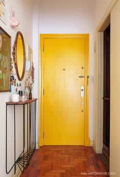 a hallway with yellow door and wooden floors