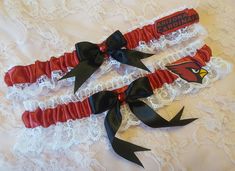 "Handcrafted wedding garter set. Created w/ apple red satin and white lace. Centered w/ black satin bow and red rhinestone. To the side sits Cardinals appliques made from lightweight cotton fabric. Garters stretch comfortably up to and at 22\". Personalization is available for an additional fee. Please leave the names and date in the box provided. If you would like a personalized ribbon for BOTH garters, please choose the personalized option in the drop down menu for your main garter, then add t Football Wedding, Wedding Garter Lace, Wedding Garter Set, Personalized Ribbon, Satin Noir, Garter Set, Wedding Garter, Arizona Cardinals, Red Satin