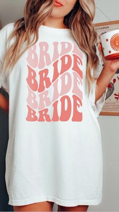 a woman wearing a white shirt with the words bridal bride printed in pink on it