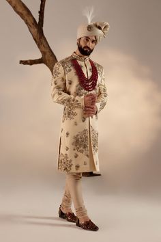 Frosted Almond Sherwani Set | Jatin Malik Introducing our masterpiece: the golden placement hand-embroidered sherwani. This exquisite sherwani showcases an intricate embroidery technique that utilizes various types of dabka and moti, creating a stunning visual impact. Paired with a wine hand-embroidered stole and matching safa, this ensemble epitomizes refined luxury and traditional excellence. Perfect for making a grand and elegant statement, this sherwani set is a testament to exceptional craftsmanship and timeless style. Included in purchase: Sherwani, Kurta, Churidar, Stole, Safa Product Specification Color: Golden Fabric: Linen silk Occasion: Engagement, Wedding, Bridal, Reception Style: Sherwani, Kurta, Churidar, Stole, Safa Care: Dry Clean Work: Hand Embroidery Customization options Semi-stitched Gold Kurta With Naqshi, Raw Silk Sherwani With Intricate Embroidery For Reception, Reception Sherwani With Intricate Embroidery In Raw Silk, Designer Gold Sets With Naqshi Detailing, Elegant Jamawar Sherwani With Intricate Embroidery, Elegant Sherwani With Intricate Embroidery In Jamawar, Gold Sherwani With Zari Work For Designer Wear, Festive Sherwani With Gold Embroidery For Festivals, Designer Wear Gold Sherwani With Resham Embroidery