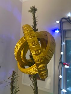 an ornament on top of a tree with lights in the background