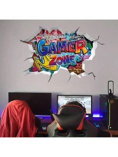 a computer desk with a laptop and monitor on it, in front of a wall that says gamer zone