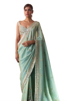 Seafoam green saree crafted in tissue with all over azura crest embroidery using sequins, bugle beads and crystals highlights. Paired with a sleeveless sweetheart neck blouse with sequin bloom embroidery and a petticoat. - Aza Fashions Sweetheart Neck Blouse, Bloom Embroidery, Crest Embroidery, Saree Gowns, Cotton Sarees Handloom, Ruffle Saree, Tissue Saree, Green Saree, Beaded Neckline