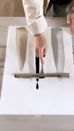 a person is using a knife to cut something on a white box with black handles