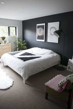 a white bed sitting in a bedroom next to a window