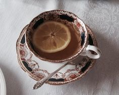 a tea cup with a slice of lemon in it