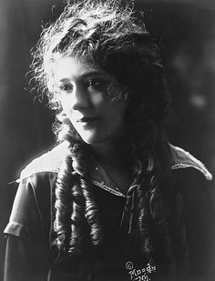 an old black and white photo of a woman with long hair