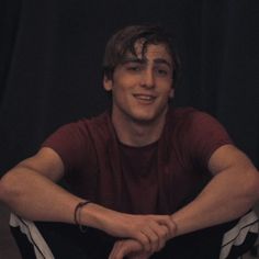 a young man sitting on the floor with his legs crossed