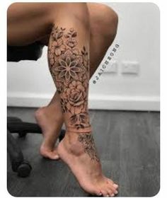 a woman's leg with flowers on it and her foot in the middle of the photo