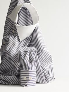 a blue and white striped shirt sitting on top of a bag