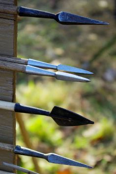 several tools are stuck in the back of a wooden box with holes for cutting wood