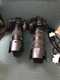 two cameras sitting next to each other on the floor