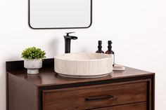 a bathroom with a sink, mirror and soap dispenser on the counter