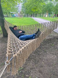 a man laying in a rope hammock