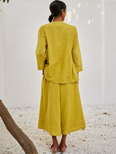 VALUES Handcrafted Organic Fair Minimal Waste CURATOR'S NOTE Handcrafted from mulmul cotton, this lime yellow co-ord set comes with a long sleeved top that has a front button opening, long sleeves and gather detailing at the side. It is paired with flared wide leg pants that come with a front zipper opening, side seam pockets and an elasticated back. It is fully lined. THE DESIGNER STORY KHARA KAPAS, meaning 'pure cotton' in Hindi, started with the belief that design is a form of expression. Tru Lime Yellow, Long Sleeved Top, Co Ord Set, Co Ord, Front Zipper, Leg Pants, Pure Cotton, Wide Leg Pants, Corn