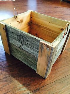 a wooden crate with the letter p on it sitting on top of a hard wood floor