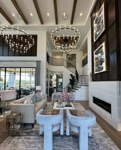 a living room filled with furniture and a fire place under a chandelier hanging from the ceiling