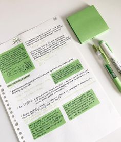 a notepad and pen sitting on top of a paper with green notes attached to it