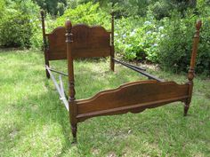 a wooden bed frame sitting in the grass