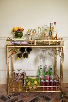 a gold bar cart filled with bottles and glasses