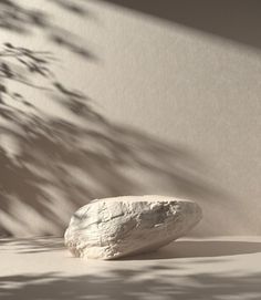 a rock sitting on top of a white floor next to a planter filled with flowers