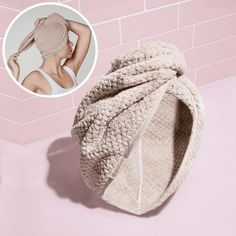 a towel wrapped around a woman's head in front of a pink brick wall