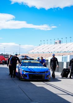 some police officers standing around a blue race car