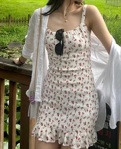 a woman standing on a wooden deck wearing a white dress