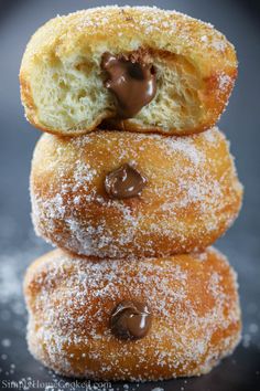 three powdered sugar donuts stacked on top of each other