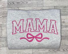 a gray shirt with pink letters and a bow on the front that says mamma