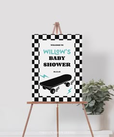 an easel with a black and white checkerboard poster on it next to a potted plant