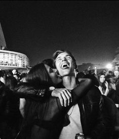 two people hugging each other in the middle of a crowd