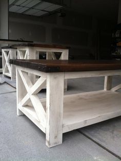 two wooden tables sitting next to each other in a warehouse floor with one table on top of the other