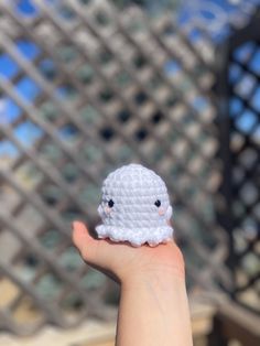 a small white crocheted object held in someone's hand