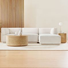 a white couch sitting on top of a hard wood floor next to a wooden wall