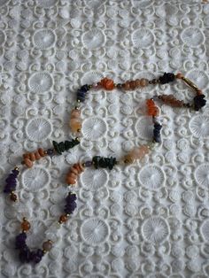 Vintage multicolored gemstone beaded necklace, featuring amethyst, carnelian, crystal quarts, onyx, agate. The necklace consists of one strand of stone chip beads, arranged by color with brass spacers between the different type of gemstones. Closes with screw barrel clasp at the back Era - 1980s Approx. Length (with clasp) - 24 inches / 61 cm Condition - Very good vintage condition, some dents on the stones! Spiritual Long Gemstone Necklace, Long Healing Necklace With Natural Stones, Gemstone Round Beads Necklaces For Meditation, Multicolor Amethyst Gemstones For Healing, Spiritual Pendant Necklace With Colorful Beads, Amber Agate Jewelry With Colorful Beads, Vintage Natural Stones Gemstones For Gift, Round Mineral Crystal Beads For Jewelry Making, Dangle Gemstone Jewelry For Meditation