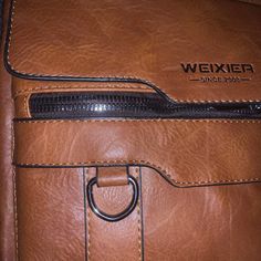 A faux brown leather bag with the look and feel of real leather. A nice bag for business or school to carry many of your essential items , including a tablet and your cell phone . It's made by the company Weixier, established in 2008. This bag is brand new without tags with a large top opening that zippers. There are front and back zippers and a pocket that snaps closed. A long canvas strap to throw over your shoulder or a convenient handle for a quick carry. An awesome useful bag for men and their daily needs, and don't forget snacks! Brown Crossbody Laptop Bag For Business, Brown Satchel With Cell Phone Pocket, Brown Crossbody Satchel With Cell Phone Pocket, Brown Travel Satchel With Cell Phone Pocket, Brown Satchel With Cell Phone Pocket For Daily Use, Brown Crossbody Laptop Bag For School, Brown Business Shoulder Bag With Mobile Phone Bag, Brown Faux Leather Shoulder Bag For School, Brown Bags With Cell Phone Pocket For School