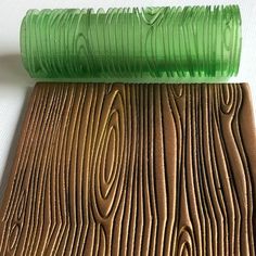 a piece of wood that has been painted green and brown with some lines on it