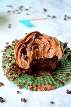 a cupcake with chocolate frosting and crumbs