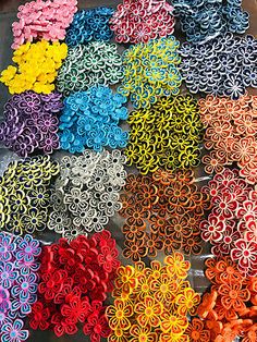 many different colors of paper flowers are arranged in the shape of circles and spirals