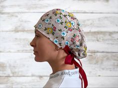 a woman with a bandana on her head wearing a white shirt and red ribbon