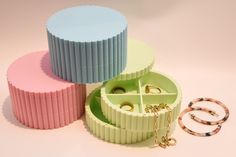 three different colored jewelry boxes sitting next to each other