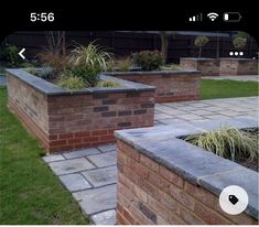 two brick planters sitting next to each other on top of a grass covered field