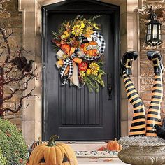 a decorated front door with pumpkins and decorations